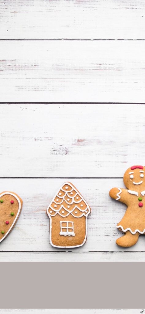 Gingerbread House & Gingerbread Man on White Wooden Phone Background