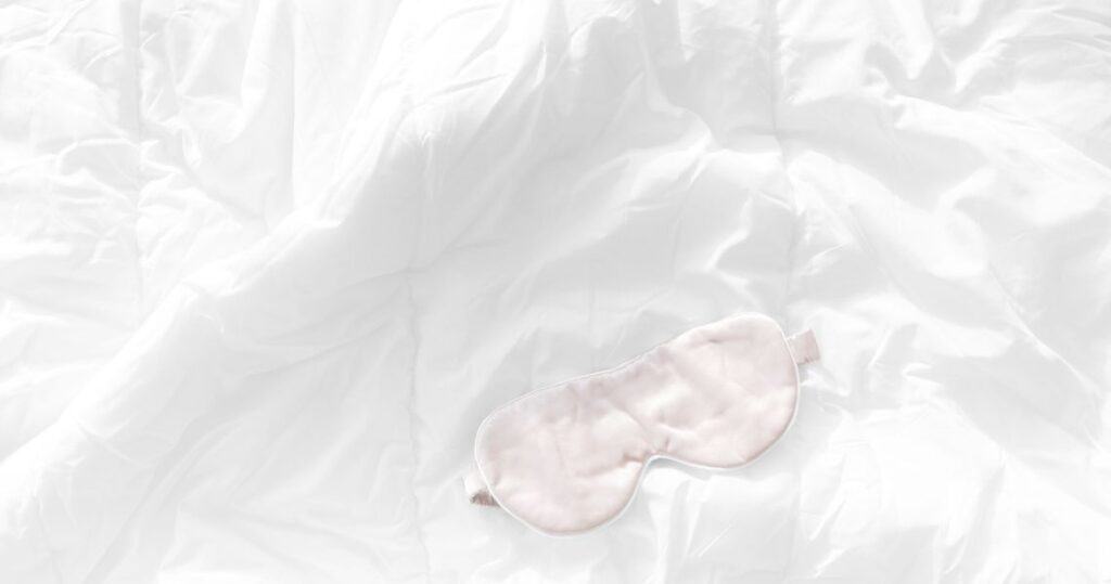 Pink sleep mask on a bed