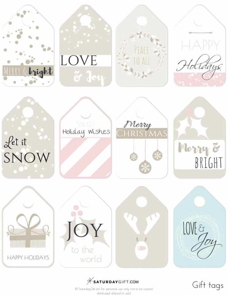 A set of 12 free printable gift tags are displayed on a white background. Each tag features a festive design in neutral and pastel pink and blue colors. Some say “love and joy,” “merry and bright,” and “let it snow”, perfect for Christmas gifts.